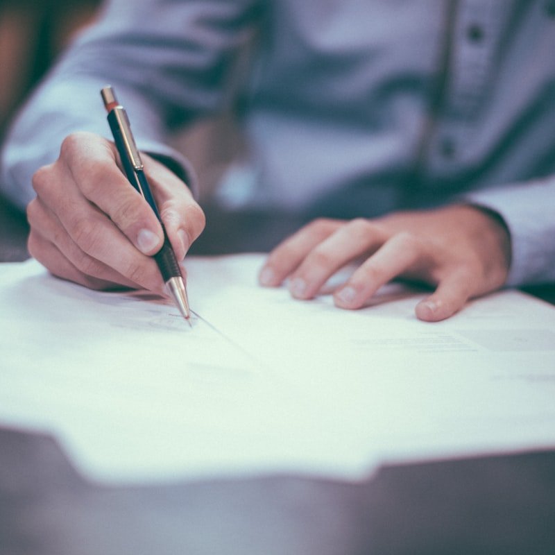 Profissional escrevendo em documentos no escritório